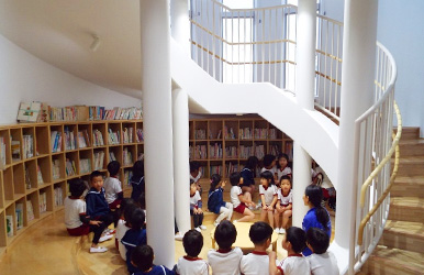 円形に並んだ書架と丸ベンチ。車座になって読み聞かせができる「こども図書館」。